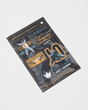 Kingz Legends Never Die Respect Youth Gi in White – flat lay: black orange graphic stickers Champion Mentality tiger eyes crown badge textual elements