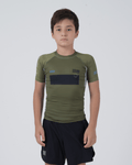 Kingz Trooper Youth Rashguard Military Green - Full Body Front View Young Boy Athlete Short Sleeve Olive Green Black Chest Band Flag Patches Gray Side Panels Black Shorts Kids BJJ [color:Military Green]