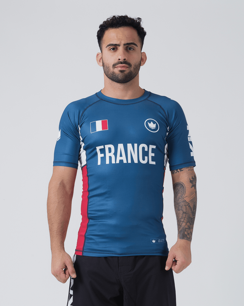 Kingz Jersey Rashguard - France Blue - Full Body Front View Male Athlete Blue Rashguard French Flag Chest Crown Badge Logo White "FRANCE" Text Red Side Panels BJJ Training Rash Guard