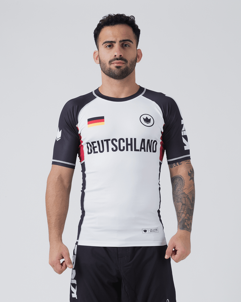 Kingz Jersey Rashguard - Deutschland White - Full Body Front View Male Athlete Black Sleeves Red Side Panels DEUTSCHLAND Text German Flag Chest Crown Badge BJJ No-Gi Training