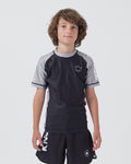 Kingz Ranked Youth S/S Rashguard Navy Gray - Full Body Front View Teen Boy Athlete Short Sleeve Navy Body Gray Raglan Sleeves White Crown Logo Chest Gray Side Stripes Matching Navy Shorts KINGZ Text Kids BJJ IBJJF Ranked