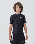 Kingz Kore V2 Youth S/S Rashguard Navy Black - Full Body Front View Teen Boy Athlete Short Sleeve Navy Blue Minimal Design White Crown Logo Circle Chest KINGZ White Sleeve Text Matching Navy Shorts Crown Logo Hem Kids BJJ Training [color:Black]