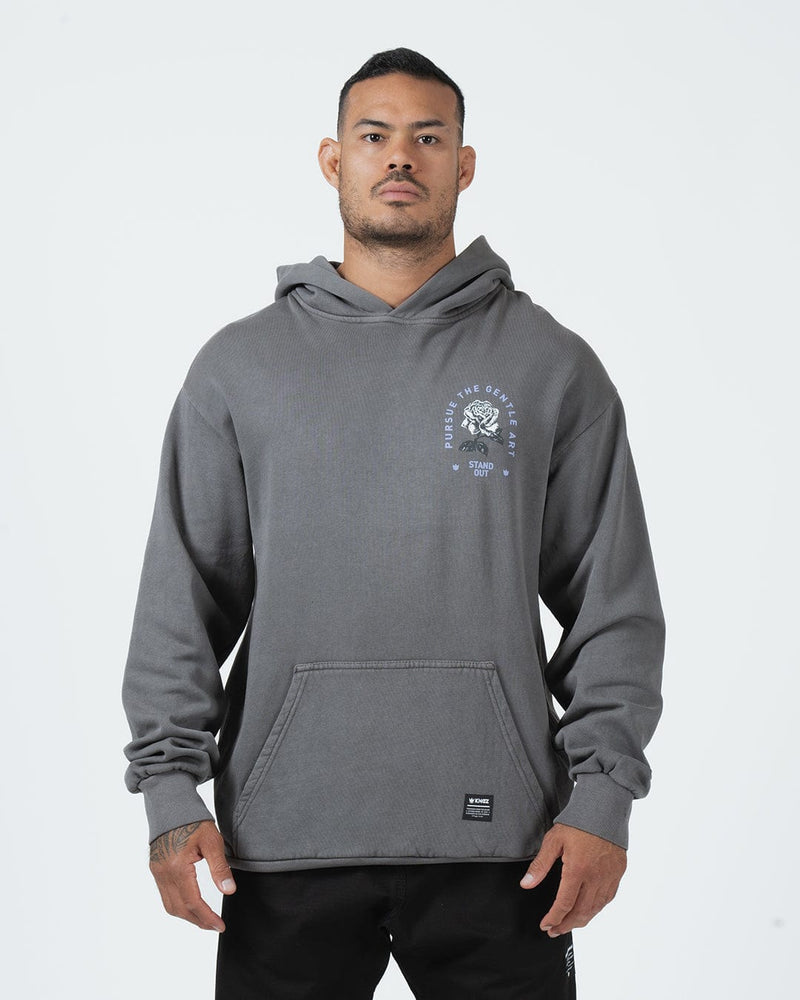 Grey BJJ hoodie front view on adult male model showing Pursue The Gentle Art rose chest graphic [color:Grey]