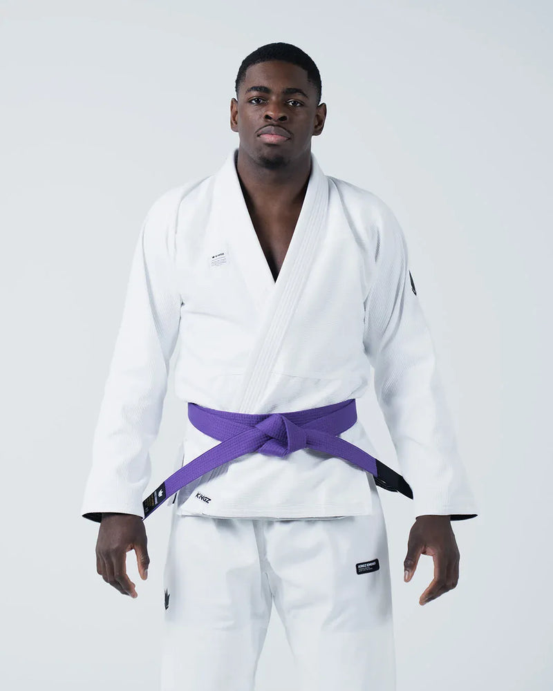 Kingz Kore V2 Jiu Jitsu Gi - White - Front View Male Athlete White Gi Black Belt Kingz Logo Left Hem Crown Badge Left Arm Traditional Cut Durable Fabric BJJ Gi Training [color:White]