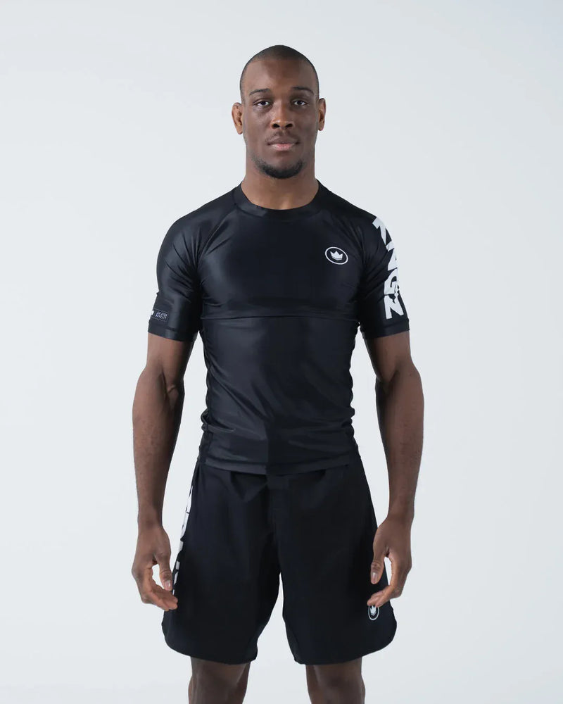 Kingz Kore V2 Short Sleeve Rashguard Black - Full Body Front View Male Athlete Black Crown Logo Chest White KINGZ Text Sleeve Sleek Fit BJJ No-Gi Grappling Rash Guard [color:Black]
