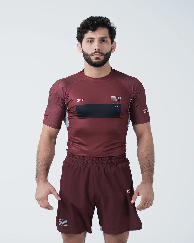 Kingz Trooper Rashguard Maroon - Full Body Front View Male Athlete Short Sleeve KINGZ Logo Black Chest Band Flag Patch Sublimated Graphics [color:Maroon]