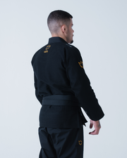 Kingz Legends Never Die Respect Gi in Black – back view on male model: black gi orange crown shoulder embroidery LND text back crown badge pants