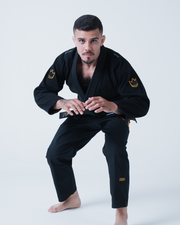 Kingz Legends Never Die Respect Gi in Black – full body front view on male model: black gi gold crown shoulder patches embroidered logos durable fabric