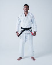 Kingz Legends Never Die Respect Gi in White – full body front view on male model: white gi black belt crown badge sleeve minimalist design apparel