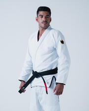 Kingz Legends Never Die Respect Gi in White – three quarter view on male model: white gi black crown badge left arm black belt contrast stitching