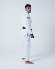Kingz Legends Never Die Respect Gi in White – side view on male model: white gi black belt crown badge shoulder and thigh durable fabric classic fit