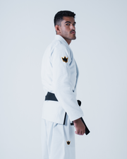 Kingz Legends Never Die Respect Gi in White – side view on male model: black belt crown badge sleeve and pants minimalist design apparel