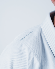 Kingz Legends Never Die Respect Gi in White – close-up detail view: embroidered "Respect is earned" text textured fabric white collar