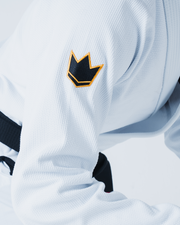 Kingz Legends Never Die Respect Gi in White – close-up detail view: black gold crown badge right sleeve textured fabric