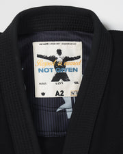 Kingz Legends Never Die Respect Women's Gi in Black – close-up detail view: inner collar label Respect Earned Not Given text black fabric texture