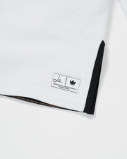 Kingz Legends Never Die Respect Youth Gi in White – close-up detail view: white textured fabric black trim le logo crown badge tribute patch