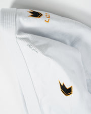 Kingz Legends Never Die Respect Women's Gi in White – close-up detail view: embroidered black gold crown badge logo text ribbed collar white fabric