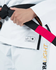 Kingz Legends Never Die Respect Women's Gi in White – close-up detail view: hand tying black belt embroidered patch logo white fabric contrast