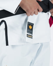 Kingz Legends Never Die Respect Women's Gi in White – close-up detail view: black belt hand Kingz crown badge logo white fabric contrast trim