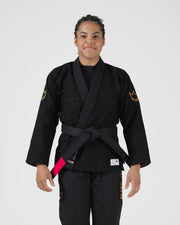 Kingz Legends Never Die Respect Women's Gi in Black – front view on female model: black gi gold crown sleeve patch pink belt tip embroidered text