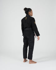Kingz Legends Never Die Respect Women's Gi in Black – back view on female model: gold crown logo embroidered shoulders black belt tailored fit durable