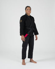 Kingz Legends Never Die Respect Women's Gi in Black – full body front view on female model: black gi gold crown badge shoulder and thigh black belt