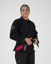 Kingz Legends Never Die Respect Women's Gi in Black – front view on female model: black gi gold crown shoulder patch red rank bar KINGZ logo lapel